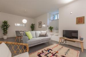 ein Wohnzimmer mit einem Sofa und einem TV in der Unterkunft Renovated Apart with Private Courtyard, By TimeCooler in Lissabon