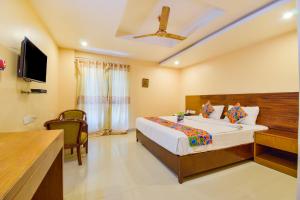 a bedroom with a bed and a flat screen tv at FabExpress Deccan Heritage Abids in Hyderabad