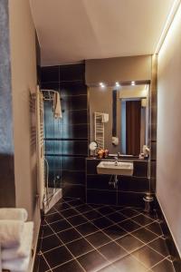 ein Bad mit einem Waschbecken und einem Spiegel in der Unterkunft Hotel Garni Klaret in Valtice