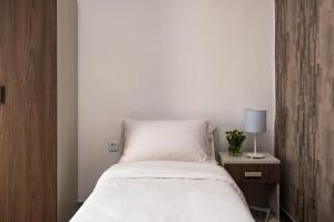 a white bed with a white bedspread and pillows at C'est La Vie Guesthouse in Marsaskala