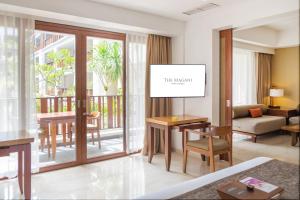 a living room with a table and a living room at The Magani Hotel and Spa in Legian