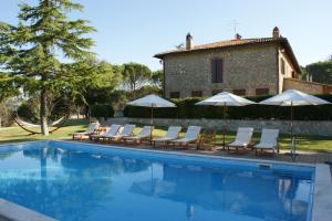 a pool with chairs and umbrellas next to a building at Scappo in Umbria, Casale Rosceto in Todi +47 photos
