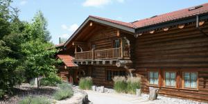 a log cabin with a balcony on top of it at Hotel Sonnenhof Aspach in Aspach
