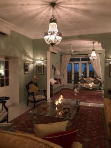 a living room with a chandelier and a couch at The Rohet House in Jodhpur