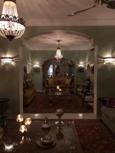 a living room with a couch and a chandelier at The Rohet House in Jodhpur