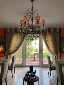 a dining room with a chandelier in front of a door at The Rohet House in Jodhpur