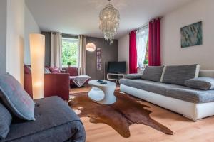 a living room with a couch and a table on the floor at Apartmenthaus am Erlbach in Buch am Erlbach