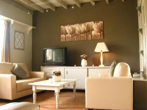 sala de estar con 2 sillas y TV en Charming Holiday Home in Zele near the Forest, en Zele