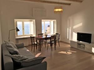 a living room with a couch and a table and chairs at Palazzo Pizzo Studio Bellavista in Pizzo