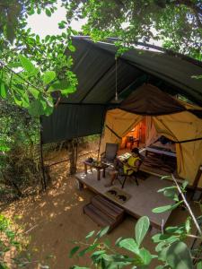 a tent with a person sitting in it at Back of Beyond Dune Camp Yala in Yala