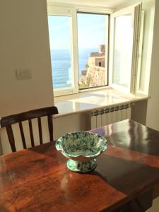 a bowl on a wooden table with a view of the ocean at Palazzo Pizzo Studio Bellavista in Pizzo +23 photos