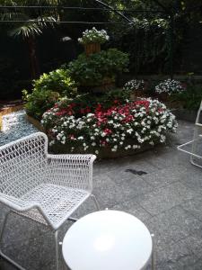 una sedia bianca e un tavolo e alcuni fiori di Hotel Malta a Milano