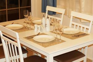 stół z białymi talerzami i kieliszkami do wina w obiekcie EasyStay Two Bedroom Apartment w Larnace