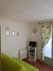 een woonkamer met een groene bank en een raam bij studio Côté Sud vert in Sarlat-la-Canéda