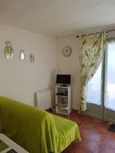 een slaapkamer met een groen bed en een raam bij studio Côté Sud vert in Sarlat-la-Canéda