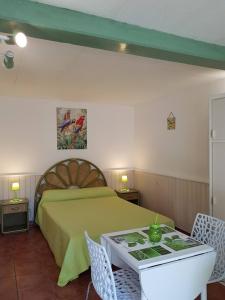 een slaapkamer met een bed en een tafel met stoelen bij studio Côté Sud vert in Sarlat-la-Canéda
