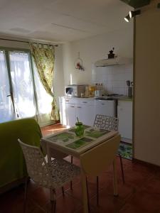 een keuken met een tafel en stoelen in een kamer bij studio Côté Sud vert in Sarlat-la-Canéda