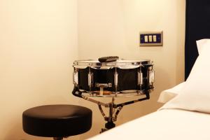 a drum and a stool next to a bed at Hotel Franklin Feel The Sound in Rome