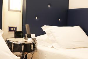 a bedroom with a bed with a drum kit on a table at Hotel Franklin Feel The Sound in Rome