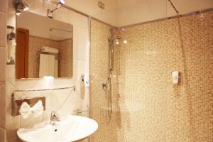 a bathroom with a sink and a shower with a glass door at Hotel Franklin Feel The Sound in Rome