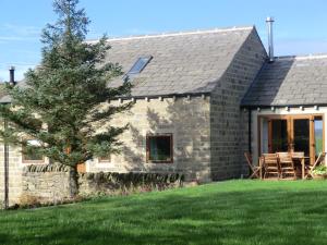 a stone house with a lawn in front of it at Hartcliffe Retreat in Penistone