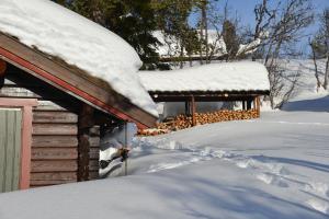 a pile of snow on the roof of a cabin at Lillesander - 3 bedroom cabin in Al