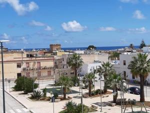 a view of a city with palm trees and buildings at Finestra Azzurra in San Vito lo Capo