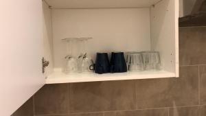 a shelf with many glass items on it in a bathroom at Camden SUITES in London