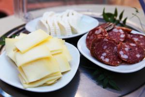three plates of cheese and other foods on a table at Hotel Franklin Feel The Sound in Rome