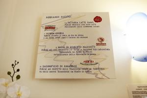 a menu hanging on a wall with flowers at Hotel Franklin Feel The Sound in Rome