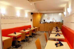 a restaurant with tables and chairs and a kitchen at Hotel Franklin Feel The Sound in Rome
