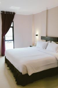 1 cama blanca grande en una habitación con ventana en Barelang Hotel Nagoya Batam en Nagoya