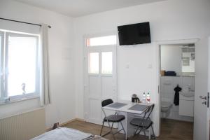 um pequeno quarto branco com uma mesa e 2 cadeiras em Ferienwohnung Möwennest I em Emden