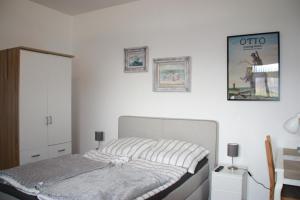 um quarto com uma cama e uma fotografia na parede em Ferienwohnung Möwennest I em Emden