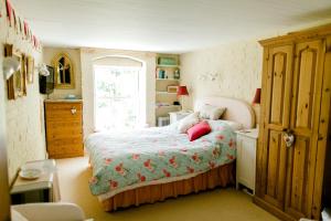 Schlafzimmer mit einem Bett und einem Fenster in der Unterkunft Cosy Cottage ground floor bedroom ensuite with private entrance in Chichester