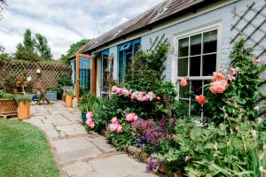 einen Garten mit Blumen vor einem Haus in der Unterkunft Cosy Cottage ground floor bedroom ensuite with private entrance in Chichester