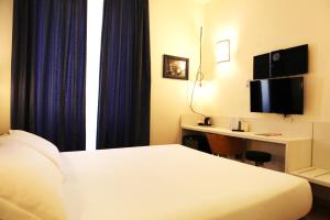 a hotel room with a bed and a desk at Hotel Franklin Feel The Sound in Rome