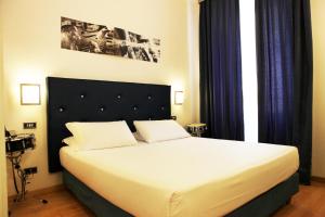 a bedroom with a large white bed with blue curtains at Hotel Franklin Feel The Sound in Rome