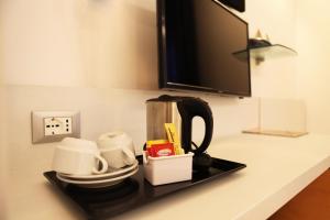 a counter with a coffee maker and cups on it at Hotel Franklin Feel The Sound in Rome