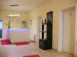 ein Raum mit einer Theke und ein Raum mit einem Kühlschrank in der Unterkunft Seebach-Hotel in Seebach