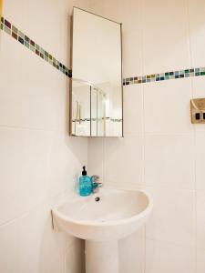 a white bathroom with a sink and a mirror at Auld Mill House Hotel in Dunfermline