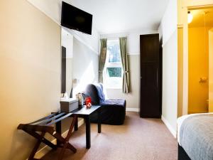 a bedroom with a couch and a table in a room at Auld Mill House Hotel in Dunfermline