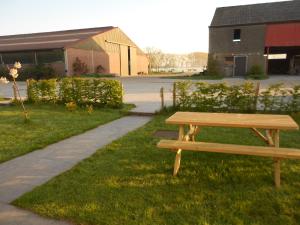 un banc en bois assis dans l'herbe à côté d'un trottoir dans l'établissement De Grote Linde, à Oostkamp