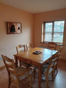 een houten tafel en stoelen in een eetkamer bij Fairfield Holiday Home No.13 in Dingle