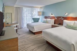 a hotel room with two beds and a desk at Zota Beach Resort in Longboat Key
