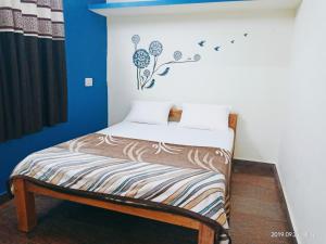 a small bed in a room with a blue wall at Freshup & Stay in Chikmagalūr