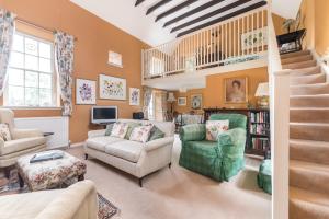 a living room filled with furniture and a staircase at Unique cosy cottage with stunning gardens in Musselburgh
