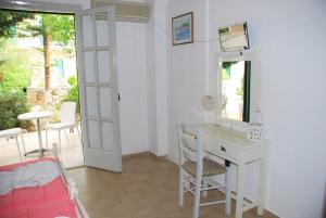 a white room with a desk and a mirror at MERLIS Studios in Kalamaki