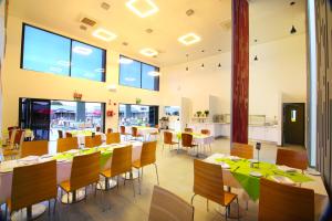 a dining room with tables and chairs and large windows at Travelodge Kasane in Kasane