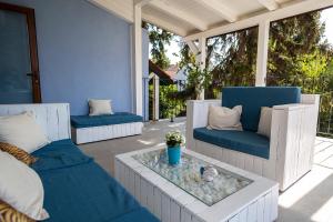 a patio with two couches and a table with a potted plant at Casa Schubert3 in Oradea